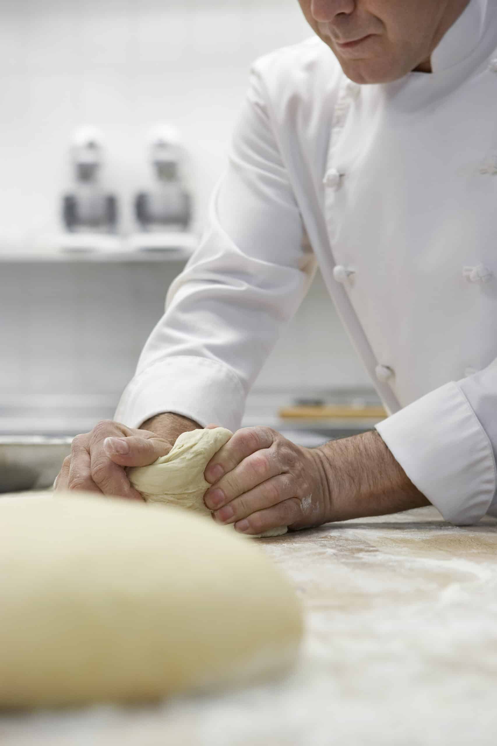 Chef preparing dough in kitchen